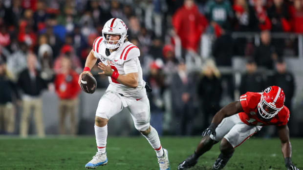 Mississippi Rebels quarterback Jaxson Dart (2) scrambles past Georgia Bulldogs linebacker Jalon Walker (11) in the first quarter at Sanford Stadium.